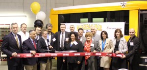 Pat Leonard of Leonard Bus Sales is seen here cutting the ribbon to officially open the new Leonard Bus Sales Type-A school bus facility in Garden City Park.